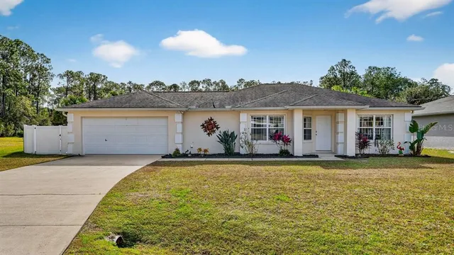 a front view of house with yard and trees in the background