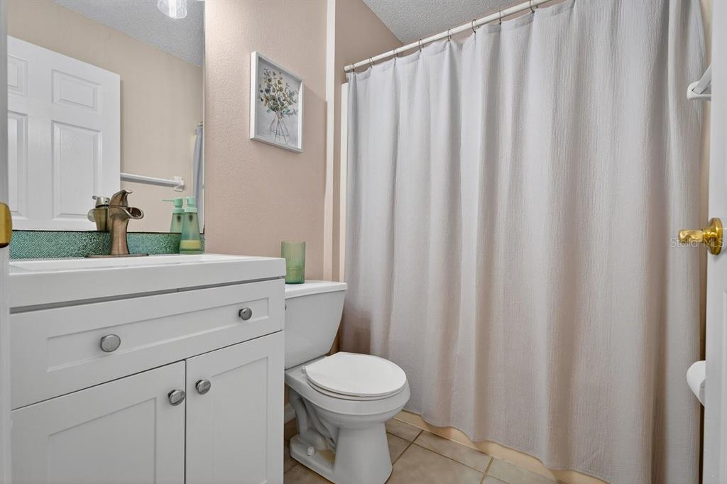 18 Smoke Tree Place Palm Coast, FL 32164 - Photo 27 of 34 a bathroom with a toilet a sink and curtain
