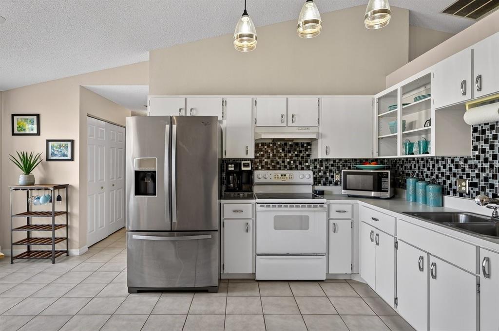 18 Smoke Tree Place Palm Coast, FL 32164 - Photo 8 of 34 a kitchen with stainless steel appliances a refrigerator sink and cabinets