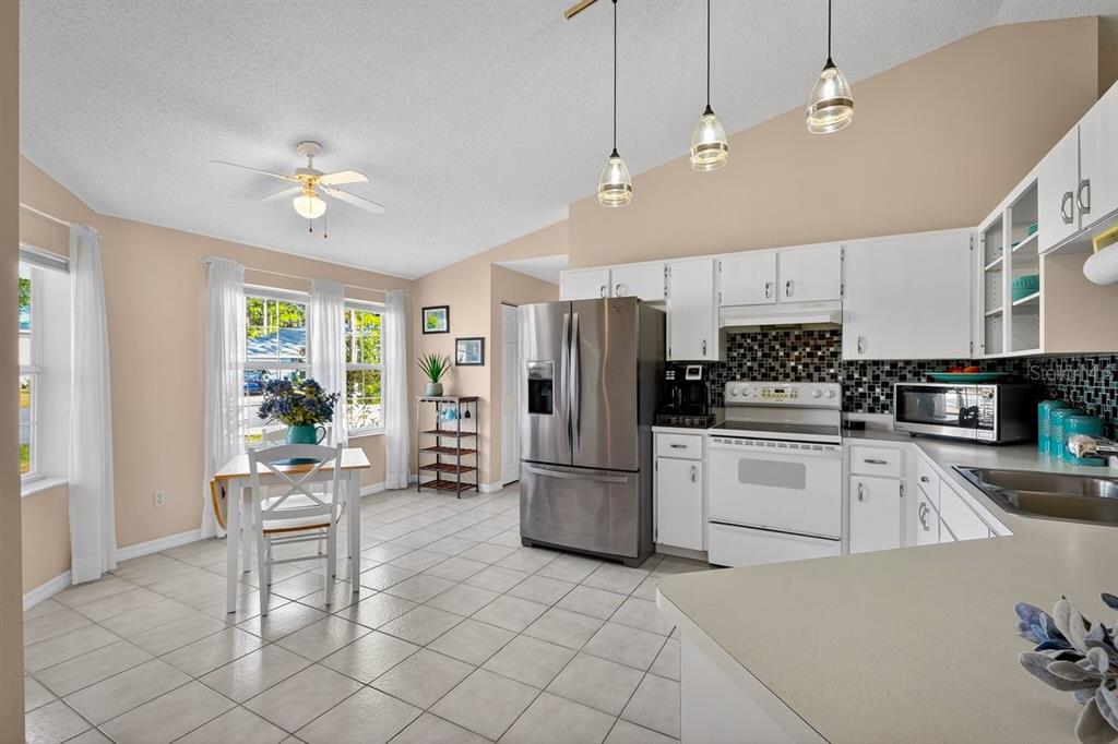 18 Smoke Tree Place Palm Coast, FL 32164 - Photo 10 of 34 a kitchen with a refrigerator and a stove top oven