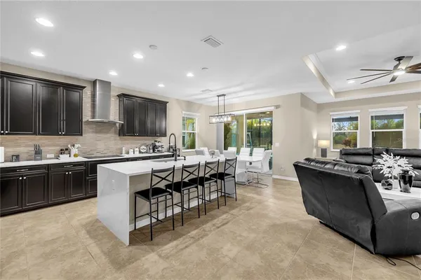 a view of a dining room and livingroom with furniture wooden floor a chandelier