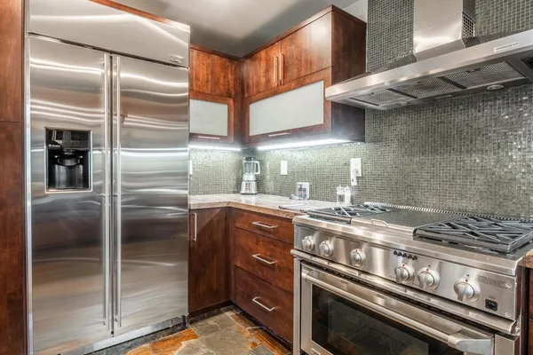 a kitchen with stainless steel appliances granite countertop a stove and a refrigerator
