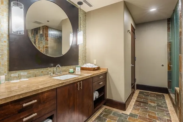 a en suite bathroom with a granite countertop double vanity sink and a mirror