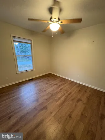 a view of an empty room with a chandelier fan
