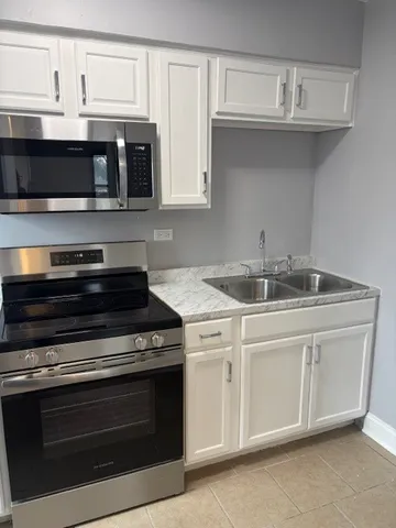 a stove top oven sitting inside of a kitchen