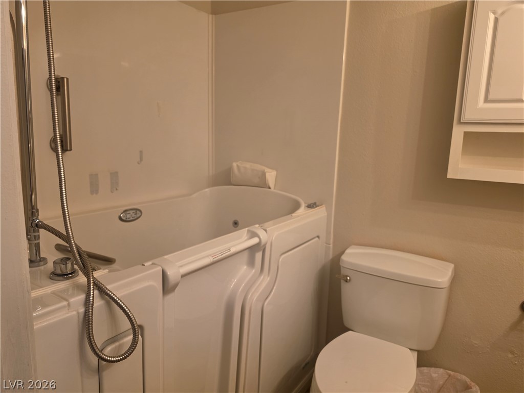 5289 Reeder Circle Las Vegas, NV 89119 - Photo 19 of 40 A functional bathroom setup highlights a specialized walk-in tub with built-in grab bars.