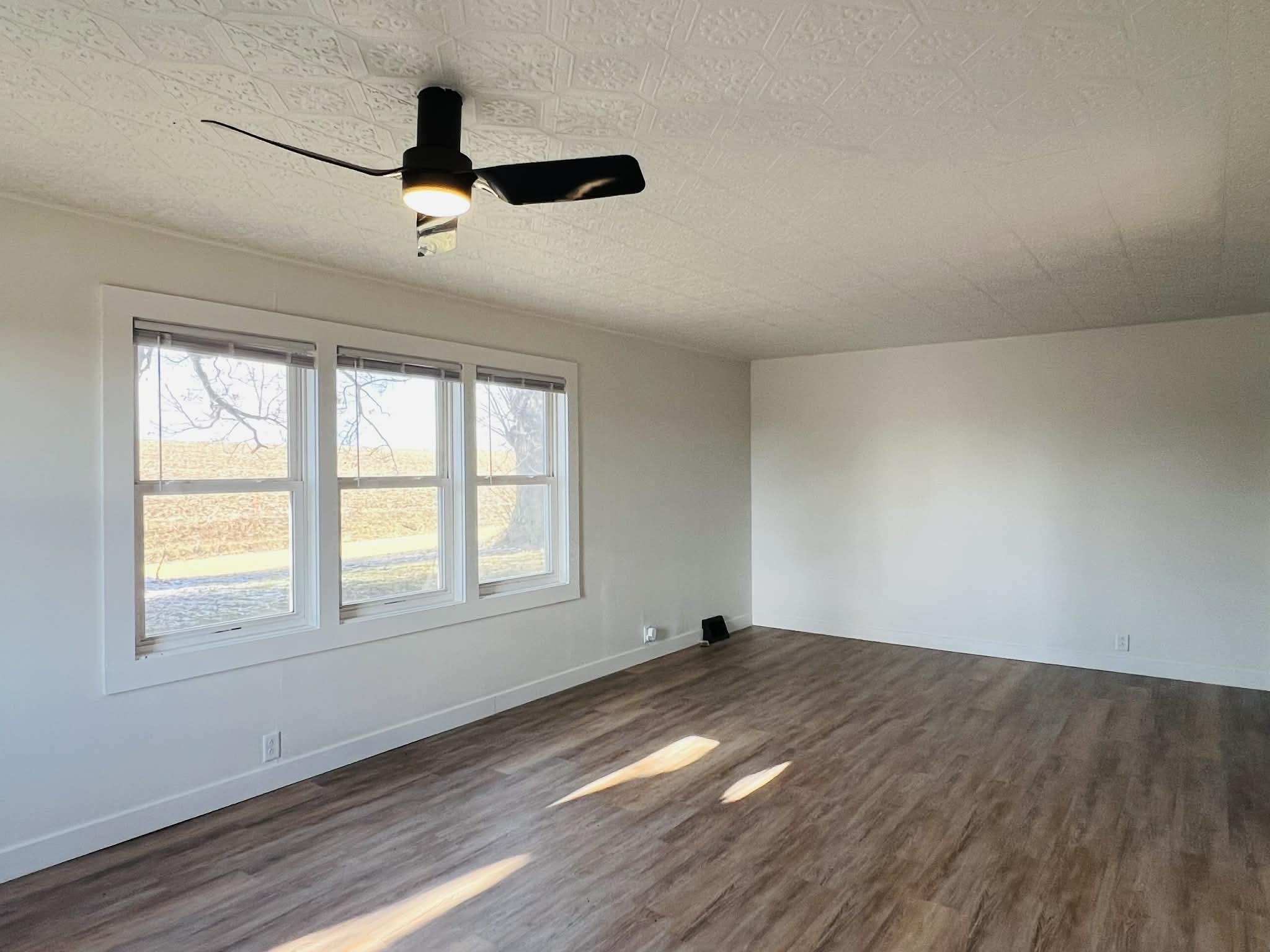 1625 South County Divide Road Pearl City, IL 61062 - Photo 13 of 30 an empty room with wooden floor fan and windows