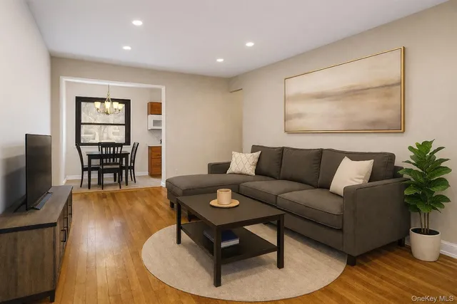 a living room with furniture a dining table and a potted plant next to a window