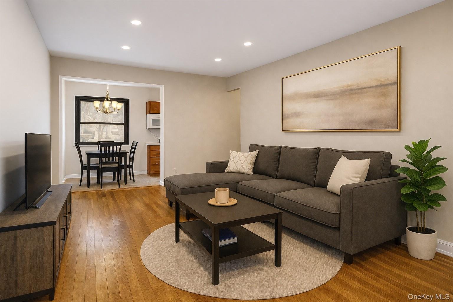 113 15th Street, Unit 1C Garden City, NY 11530 - Photo 5 of 14 a living room with furniture a dining table and a potted plant next to a window