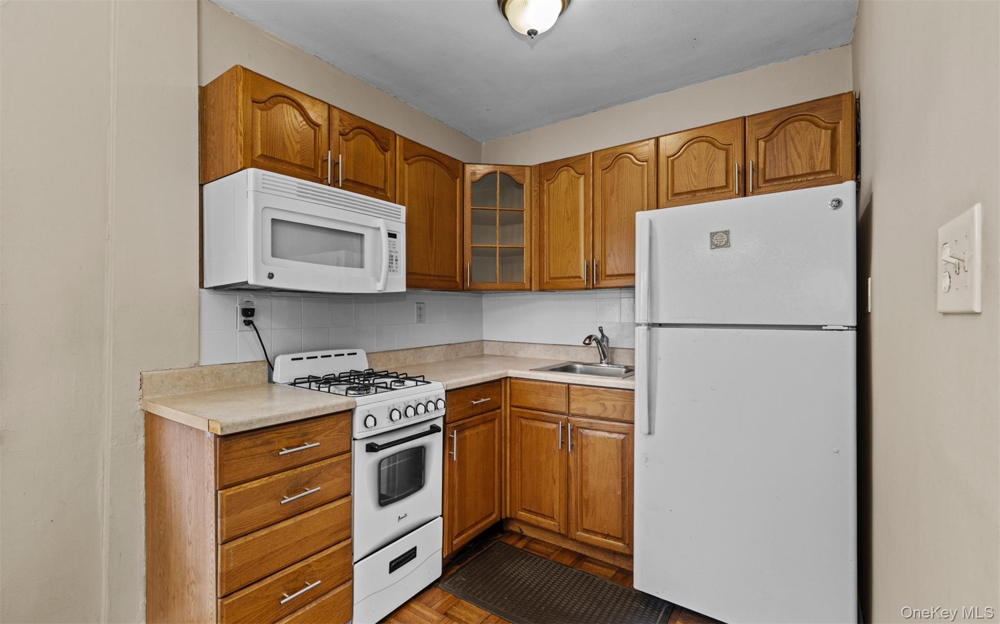 113 15th Street, Unit 1C Garden City, NY 11530 - Photo 7 of 14 a kitchen with a refrigerator sink and microwave