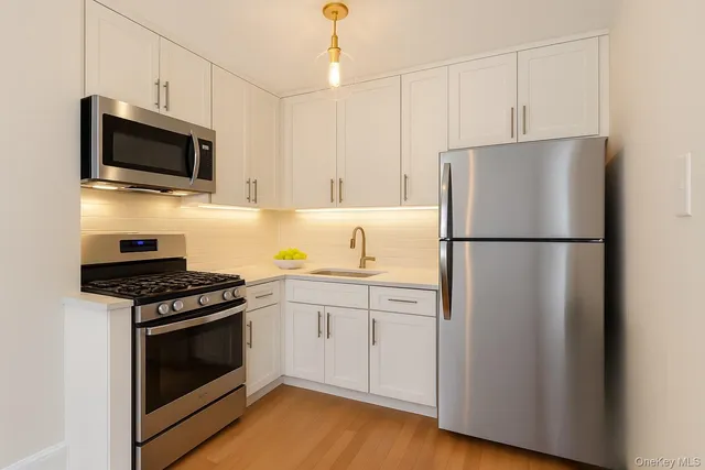 a kitchen with stainless steel appliances a refrigerator stove and microwave