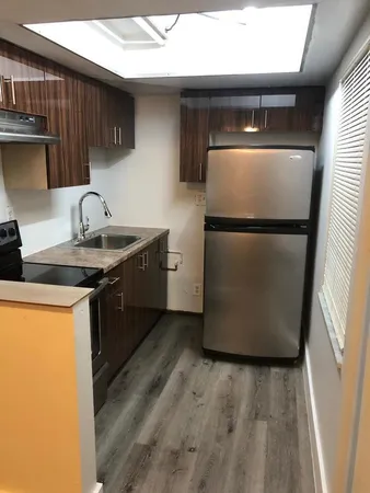a kitchen with a sink a refrigerator and a stove