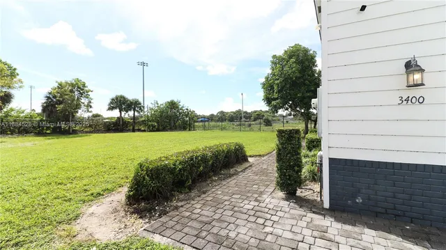 a view of a lake with a big yard and potted plants