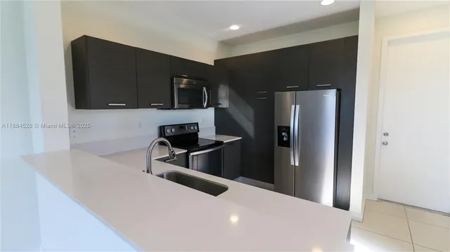 a kitchen with stainless steel appliances a refrigerator and a microwave