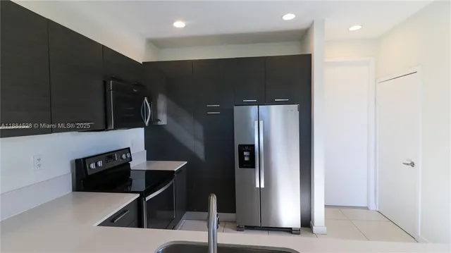 a kitchen with stainless steel appliances kitchen island a refrigerator and a microwave