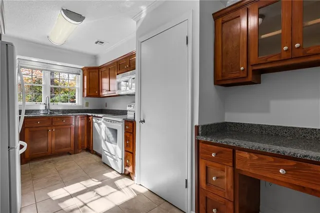a kitchen with stainless steel appliances granite countertop a stove a sink and a refrigerator