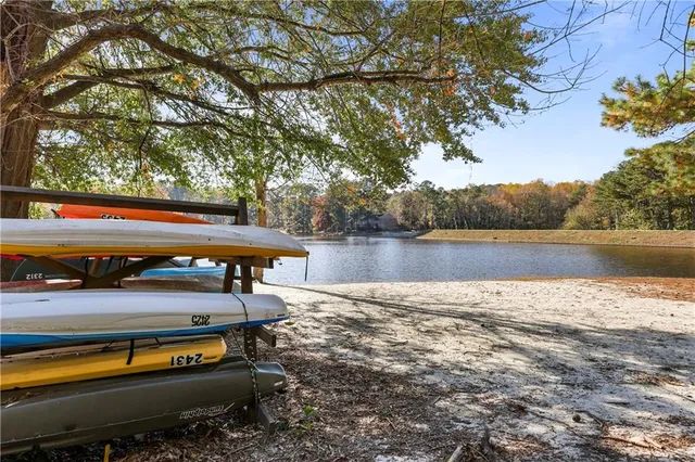 a view of swimming pool with lake and trees in the back