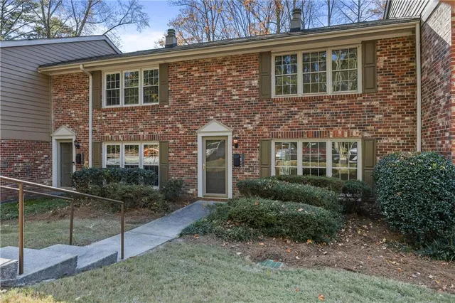 a view of a brick house many windows and yard