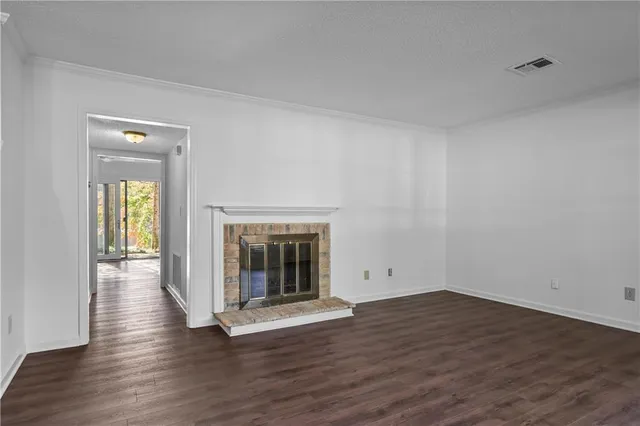a view of empty room with wooden floor and fireplace