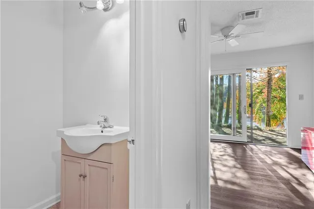 a bathroom with a sink a mirror and next to a window