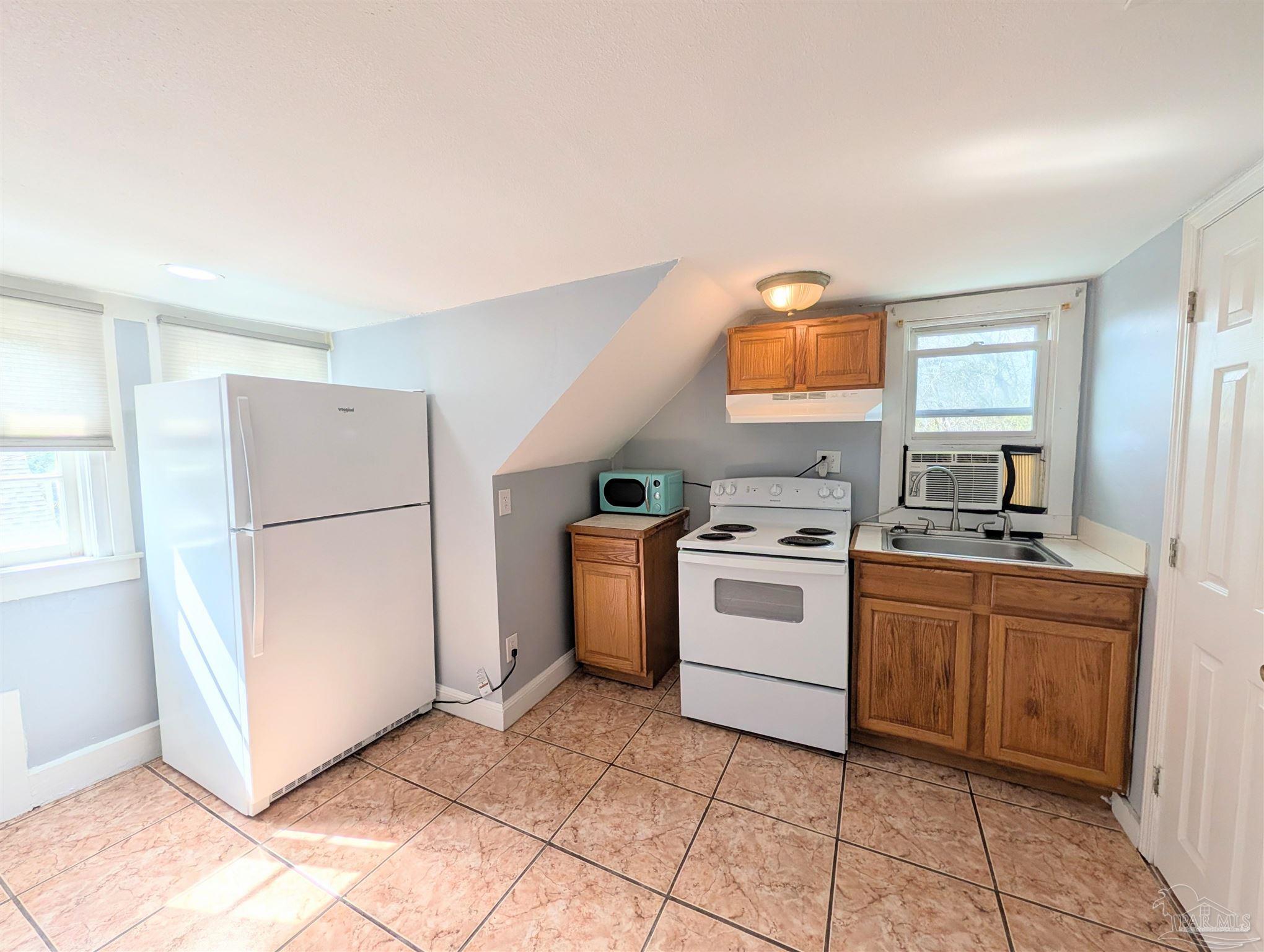 911 North Spring Street, Unit 4 Pensacola, FL 32501 - Photo 12 of 16 a kitchen with a stove top oven and cabinets