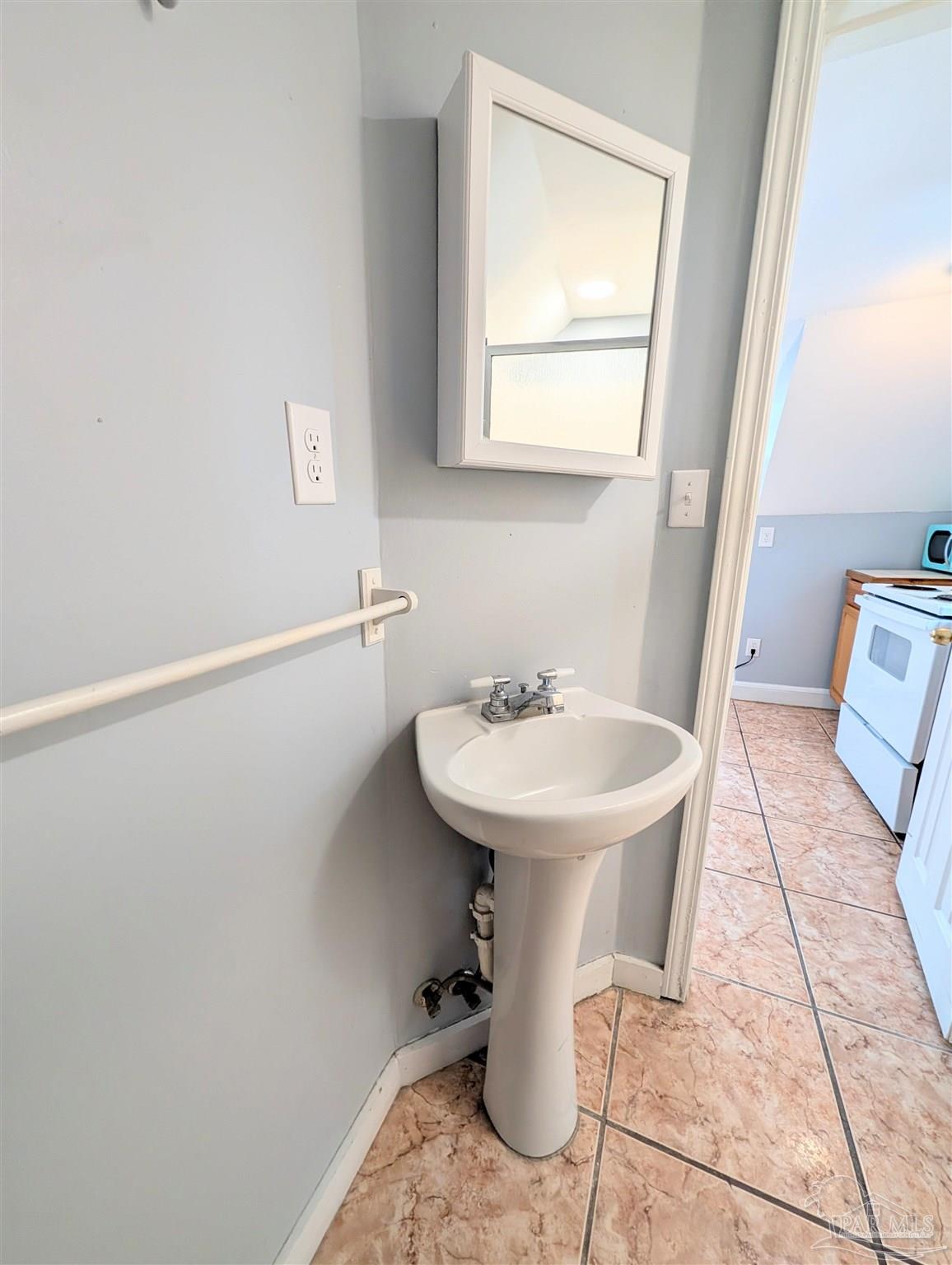 911 North Spring Street, Unit 4 Pensacola, FL 32501 - Photo 15 of 16 a bathroom with a sink a toilet and mirror
