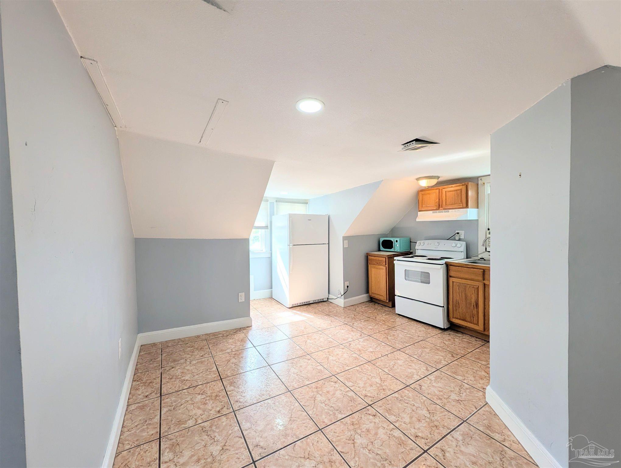 911 North Spring Street, Unit 4 Pensacola, FL 32501 - Photo 9 of 16 a view of a kitchen with furniture and an empty room