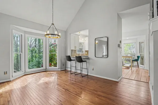 a view of a livingroom with wooden floor and furniture