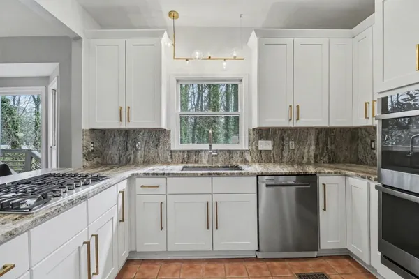 a kitchen with stainless steel appliances granite countertop a sink stove and cabinets