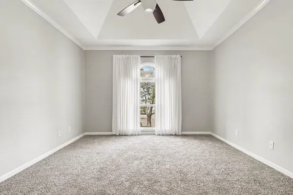 an empty room with ceiling fan and window