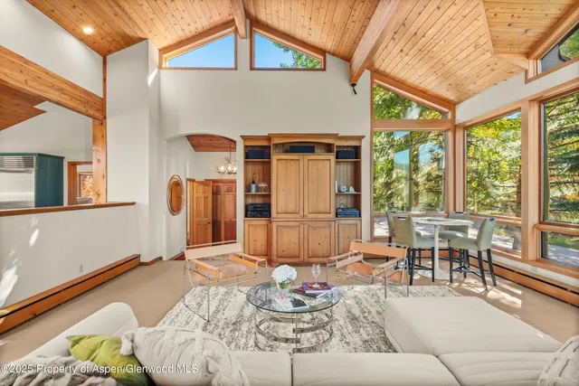 a living room with furniture and floor to ceiling windows