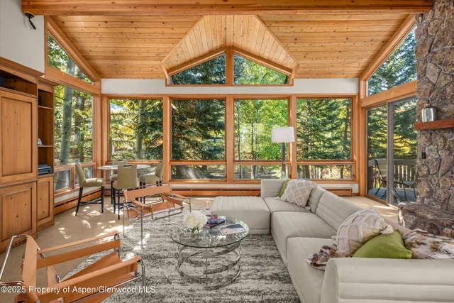 a living room with fireplace furniture and a large window