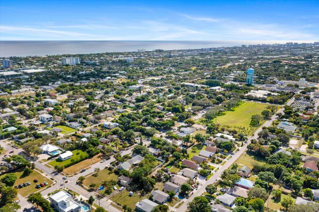 an aerial view of residential houses with outdoor space and trees all around