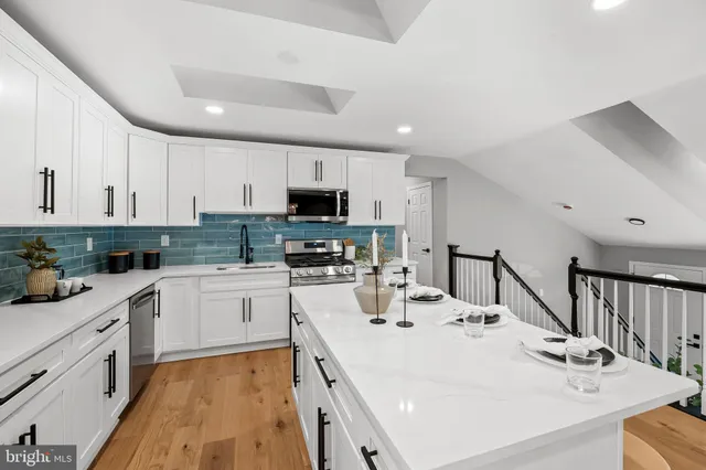 a kitchen with white cabinets and appliances