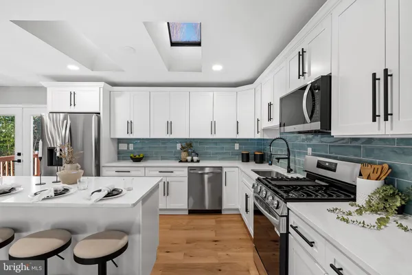 a open dining room with stainless steel appliances kitchen island granite countertop a dining table chairs and view living room