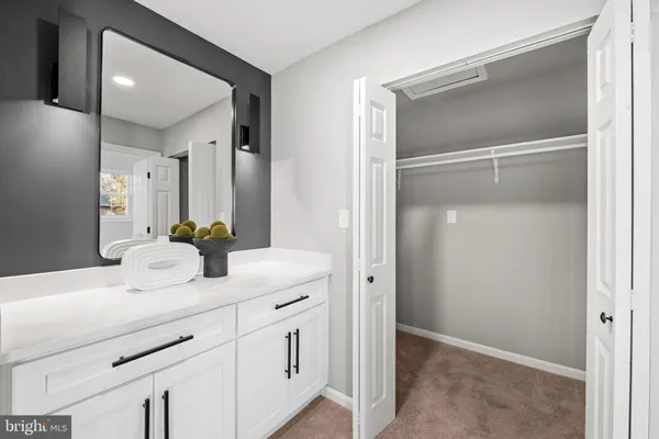 a bathroom with a granite countertop toilet sink and mirror