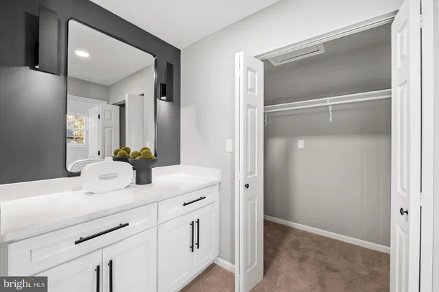 a bathroom with a granite countertop toilet sink and mirror