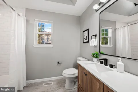 a view of empty room with kitchen and fireplace