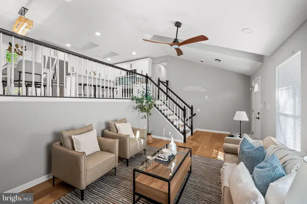 a living room with furniture and a ceiling fan