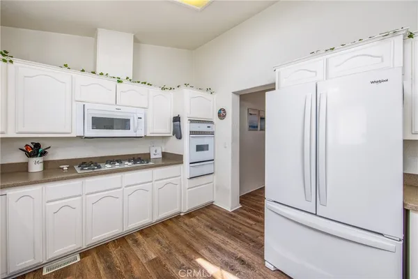 a kitchen with white cabinets and refrigerator