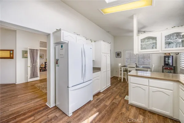 a kitchen with a refrigerator and white cabinets
