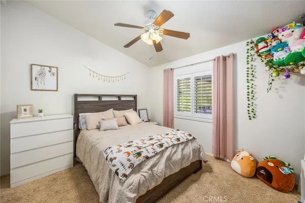 a bedroom with a bed and a chandelier fan