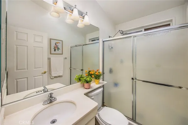 a bathroom with a sink mirror and a shower