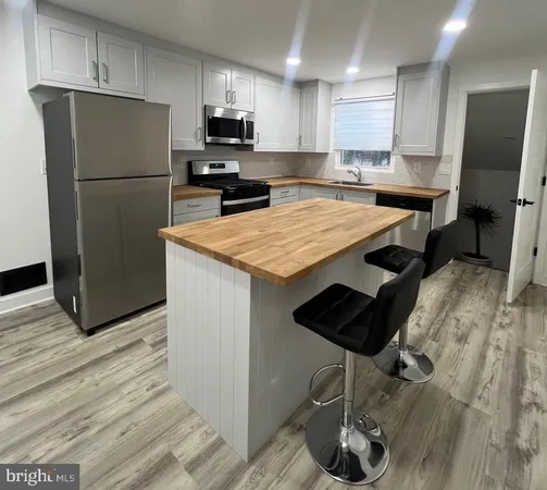 a kitchen with stainless steel appliances granite countertop a refrigerator a stove a sink and a microwave