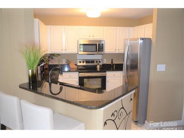 1313 Torrence Circle Davidson, NC 28036 - Photo 4 of 20 a kitchen with stainless steel appliances granite countertop a refrigerator a stove and a sink with wooden floor
