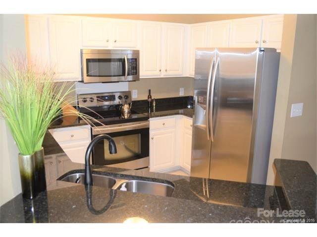 1313 Torrence Circle Davidson, NC 28036 - Photo 5 of 20 a kitchen with a stove a microwave and a refrigerator