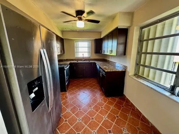 a living room with stainless steel appliances furniture and a window