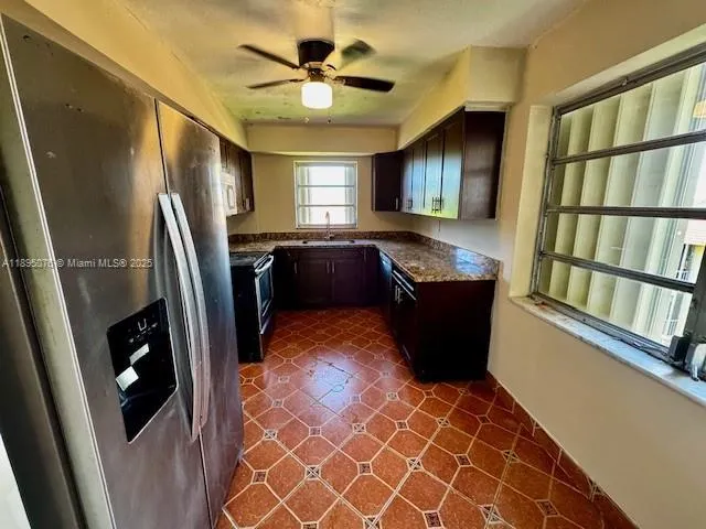 a living room with stainless steel appliances furniture and a window