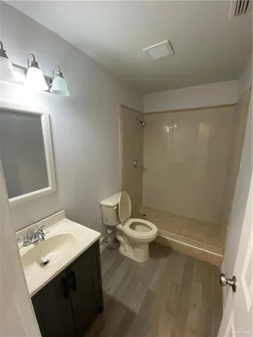 a bathroom with a sink a toilet a mirror and shower