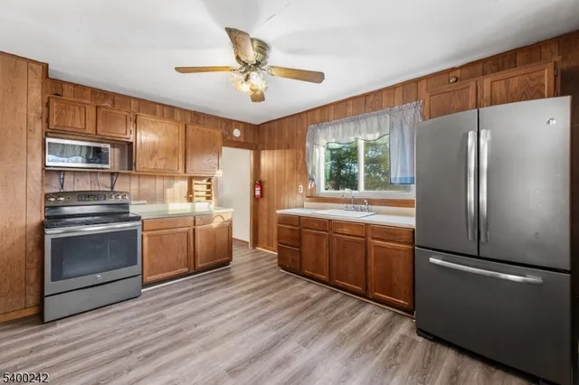 a kitchen with a refrigerator cabinets and wooden floor